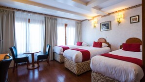 Une chambre d’hôtel avec deux lits, une table à manger et des chaises.