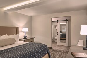 Une chambre d’hôtel comprenant un lit, des tables de chevet, un bureau et une chaise.