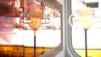 A window with two spherical lamps and a view of a yellow building outside.