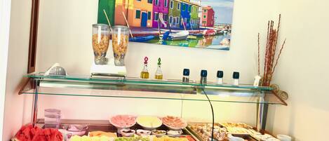 A buffet with various food items and a juice dispenser.