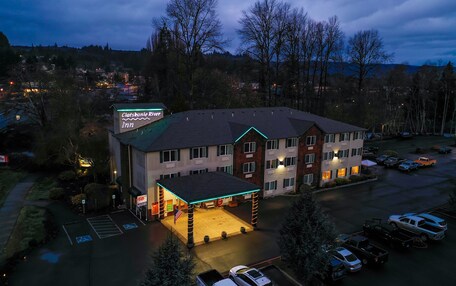 A hotel with a covered parking area, accessible parking, and a sign indicating the name and location.