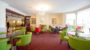 A hotel lobby with green chairs, a red carpet, and a chandelier. - Hermitage Hotel OCEANA COLLECTION (Bournemouth)