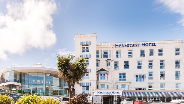A multi-story building with the name "Hermitage Hotel" on the facade.