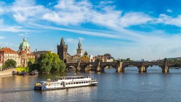 A river with a bridge, boats, and historic buildings.