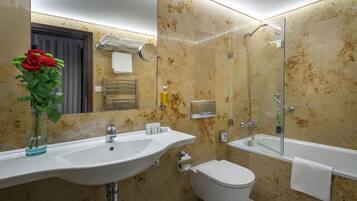 A bathroom with a sink, toilet, and shower.