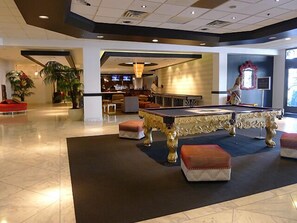 A spacious lobby with a pool table, comfortable seating, and a bar area. - Royal Vacation Suites (Las Vegas)