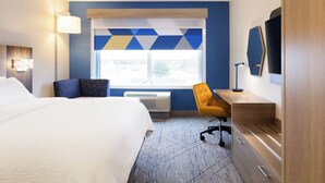A hotel room with a bed, a desk, a chair, a window with a view, and a TV on the wall. - Holiday Inn Express Hotel & Suites Winchester by IHG (Winchester)