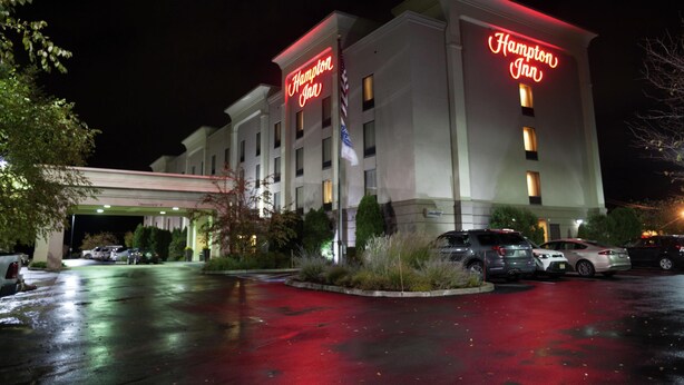 A Hampton Inn hotel with a parking lot and several cars parked in front. - Hampton Inn Oneonta (Oneonta)
