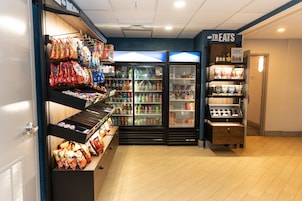 Espaço com máquinas de venda automática de lanches e bebidas, oferecendo diversos produtos.