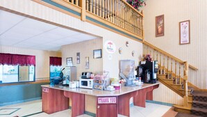 Un espace dédié au petit-déjeuner, comprenant un comptoir en bois, un four à micro-ondes et une machine à café.