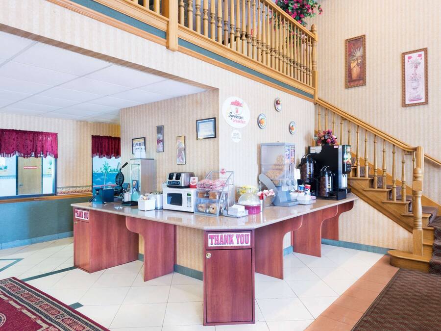 A breakfast area with a wooden counter, a microwave, and a coffee machine.