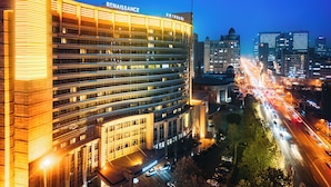A multi-story hotel with a prominent "Renaissance" sign, surrounded by a busy urban street at night.