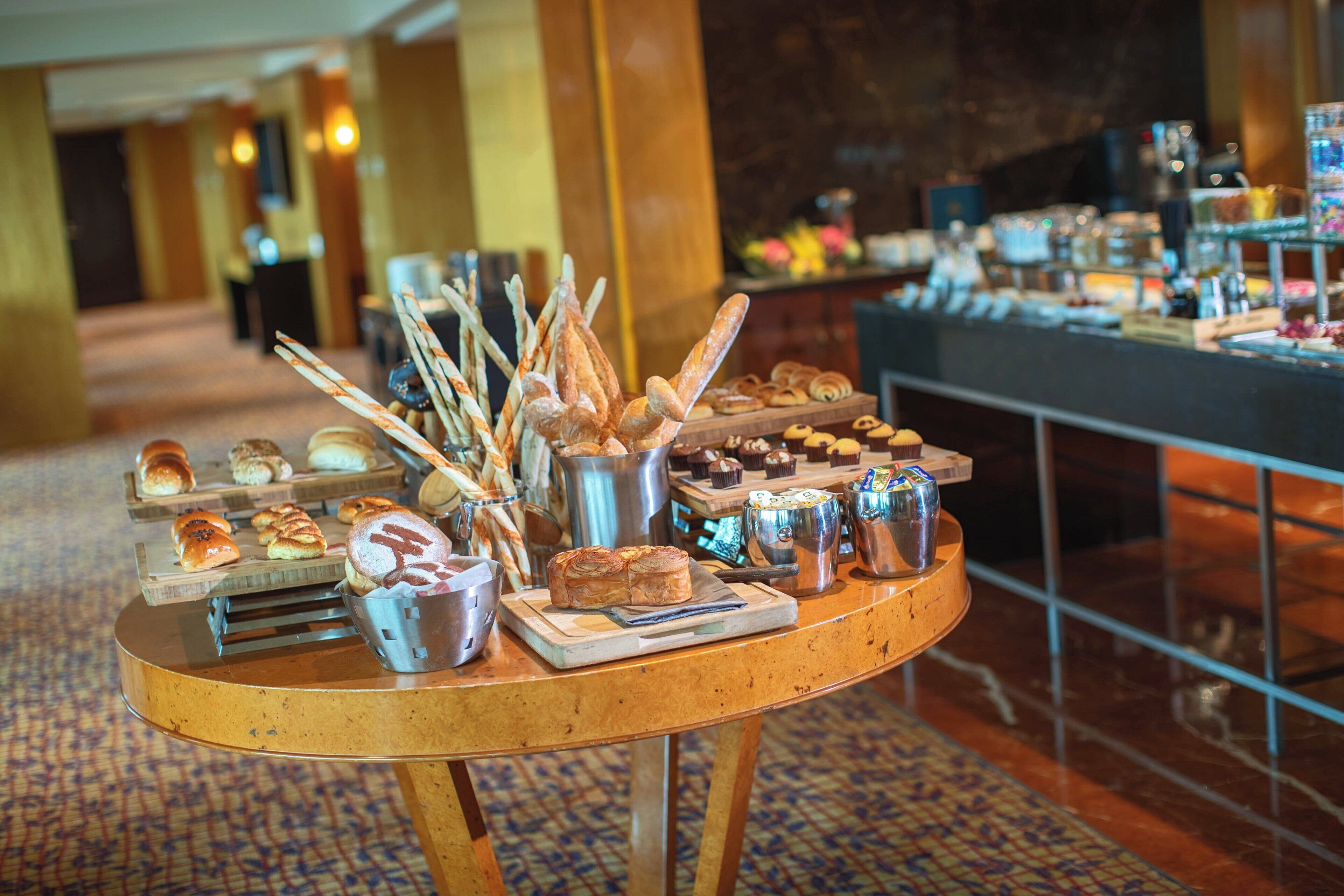 Una mesa de buffet con diversos productos horneados y pasteles.