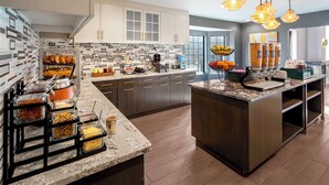 A modern kitchen with a marble countertop, built-in cabinets, and a breakfast bar. - Homewood Suites by Hilton Eatontown (Eatontown)