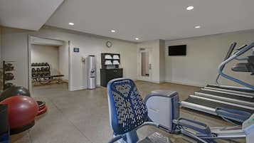 A gym with treadmills, exercise balls, and weights.