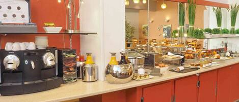 A buffet setup with coffee machines, a variety of food items, and a mirror reflecting the dining area.
