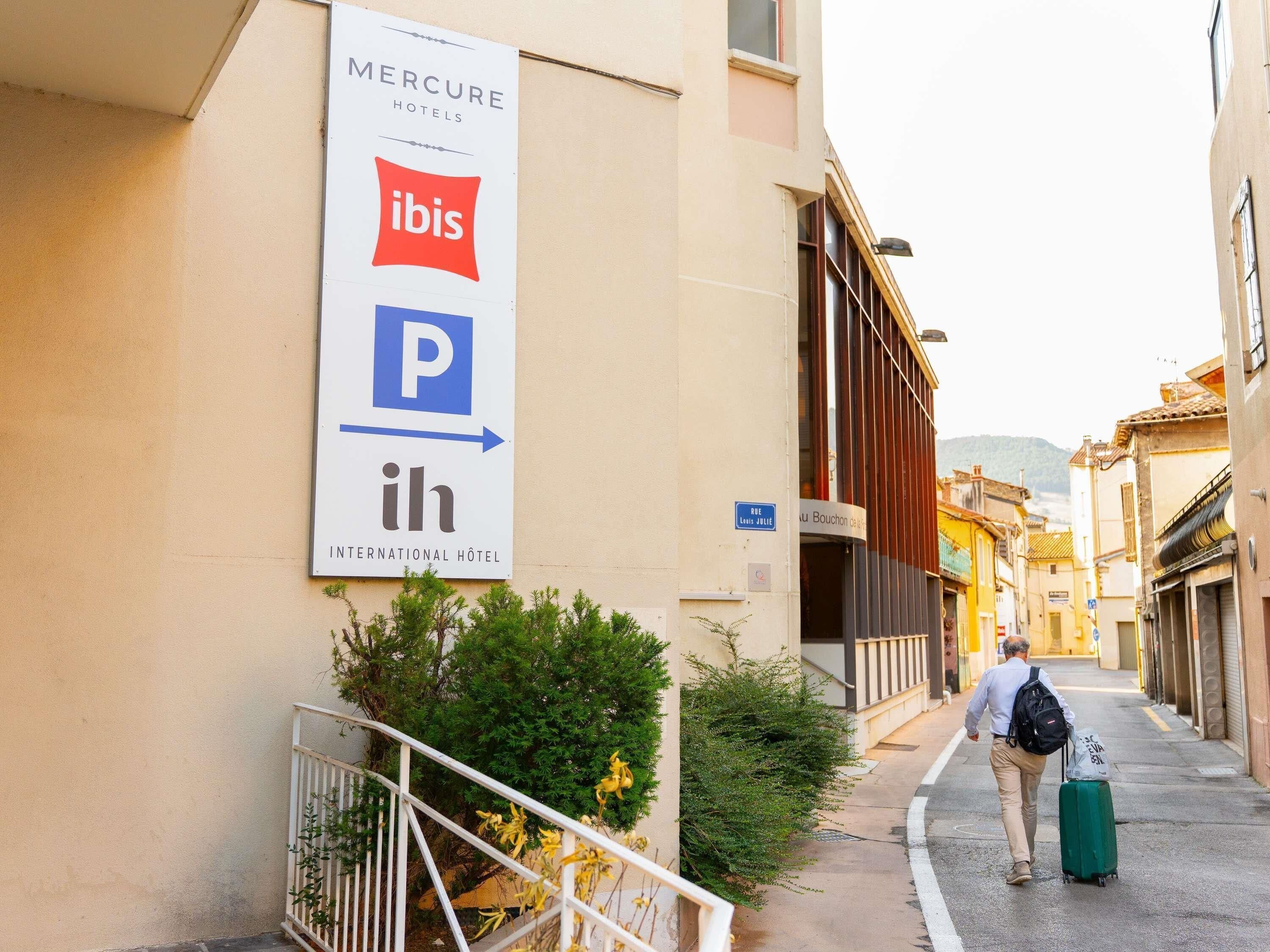 Une enseigne d’hôtel Mercure avec un symbole de stationnement et un logo d’hôtel international.