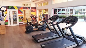A gym with treadmills, a stationary bike, and a rowing machine.