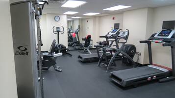 A gym with treadmills, elliptical machines, and weightlifting equipment.