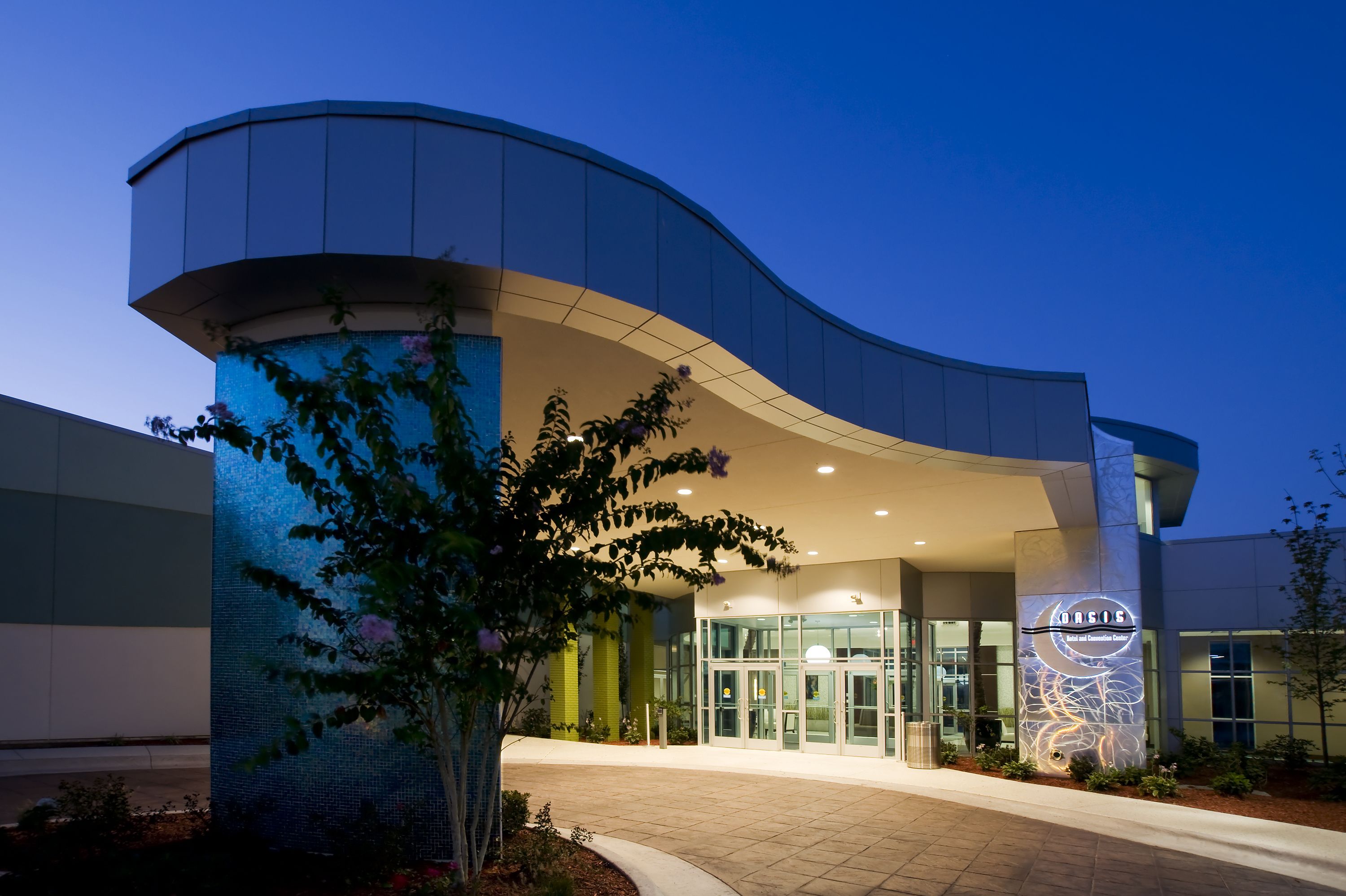 A modern building with a curved entrance, glass doors, and a sign reading "Basis".