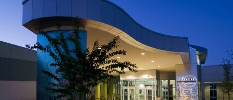A modern building with a curved entrance, glass doors, and a sign reading "Basis".