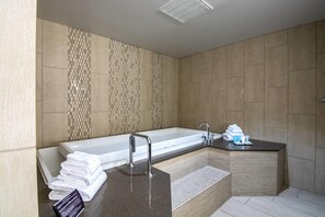 A modern bathroom with a large bathtub, a separate shower area, and a vanity with a sink.