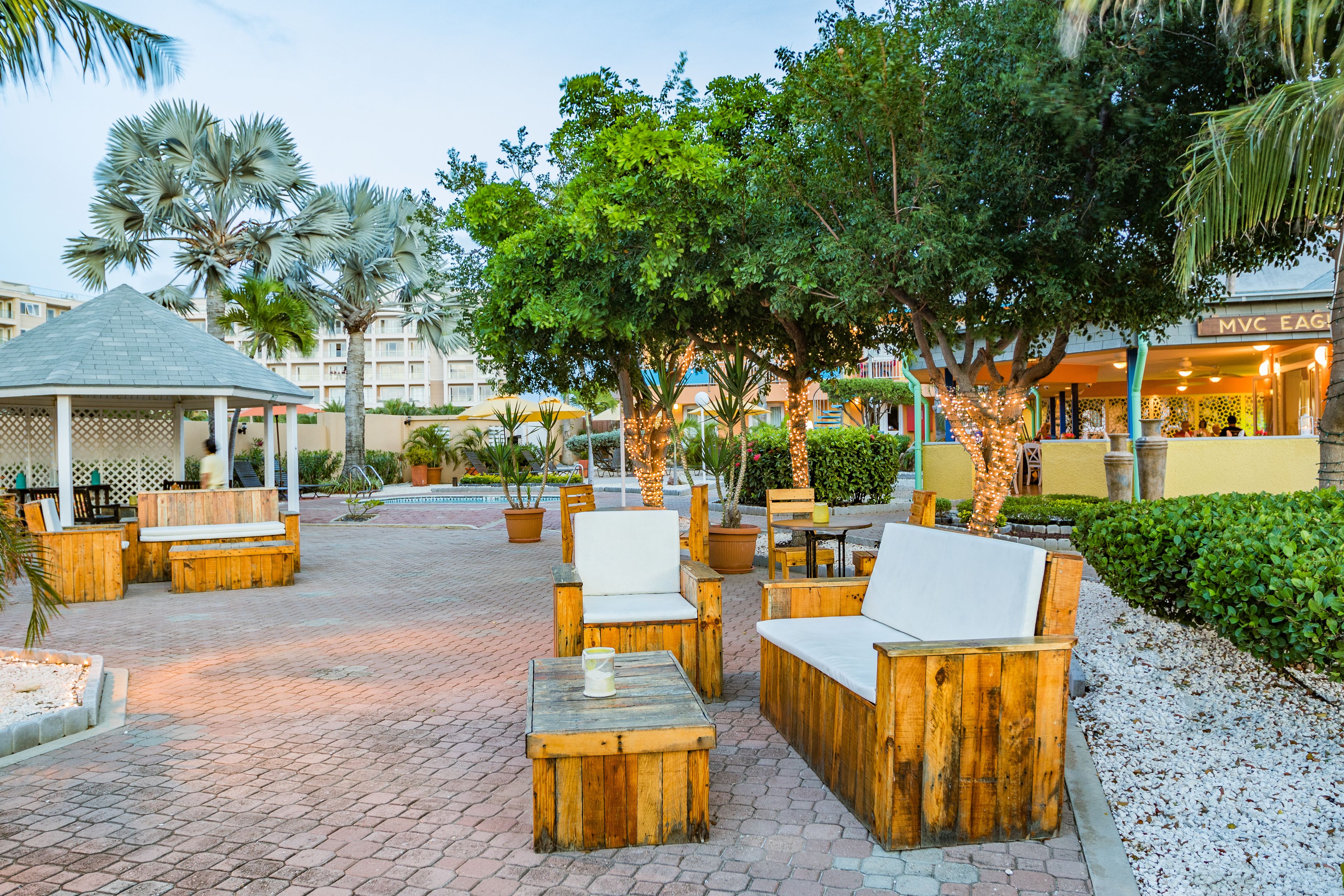 An outdoor seating area with wooden furniture and potted plants.