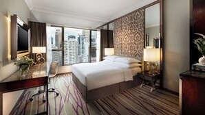 A hotel room with a large bed, a desk with a chair, a desk lamp, a mirror, and a view of the cityscape. - Dorsett Wanchai Hong Kong (Hong Kong)