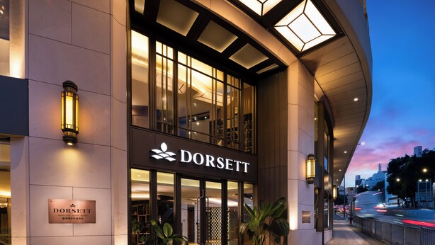 A modern hotel entrance with a glass facade, a sign reading "DORSETT," and potted plants at the entrance. - Dorsett Wanchai Hong Kong (Hong Kong)