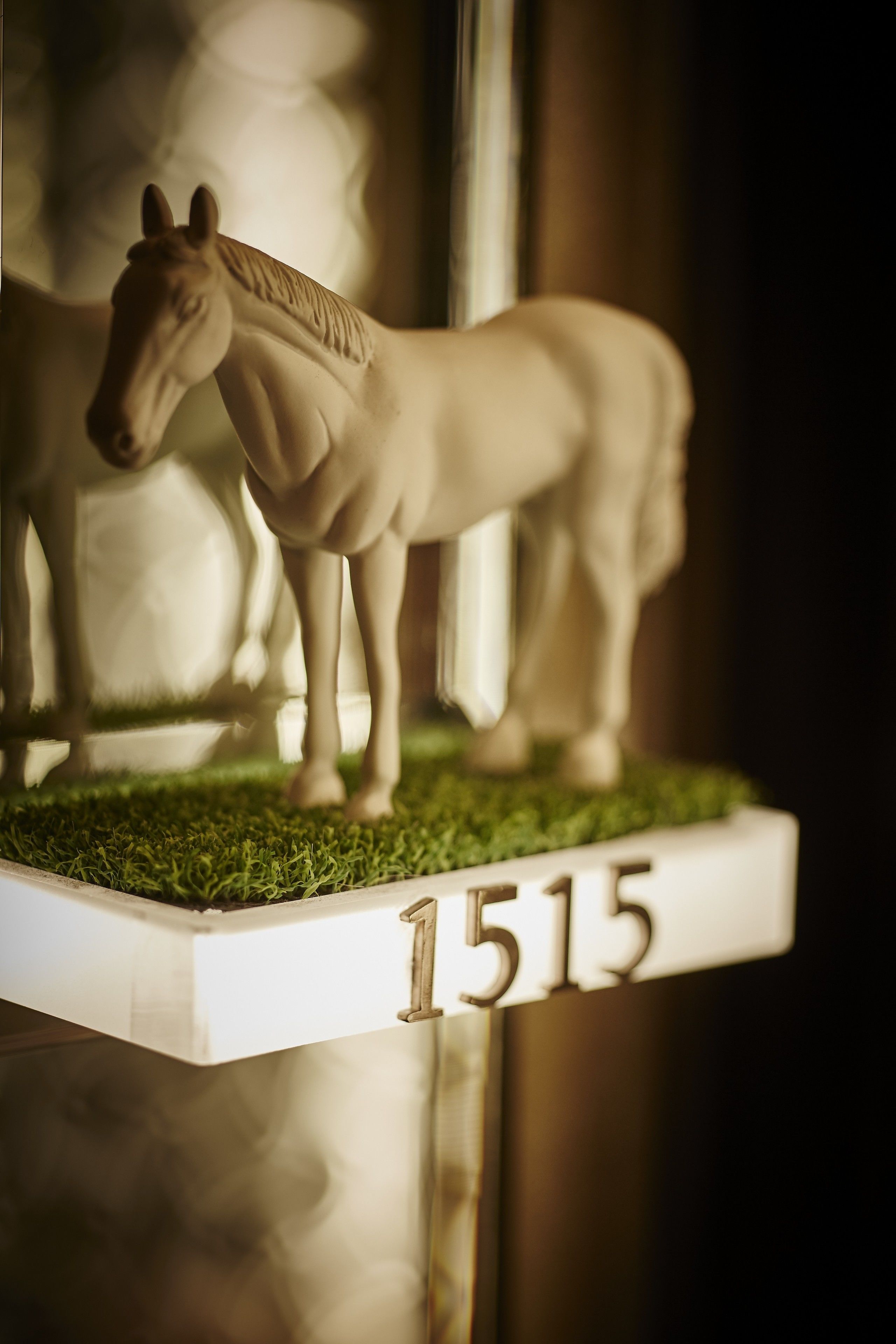 A white horse figurine on a white pedestal with the number 1515.