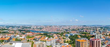 A cityscape with a mix of residential and commercial buildings, a river, and a clear blue sky.