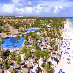 Relax by the pool surrounded by palm trees and thatched umbrellas, with access to the beach and turquoise waters.