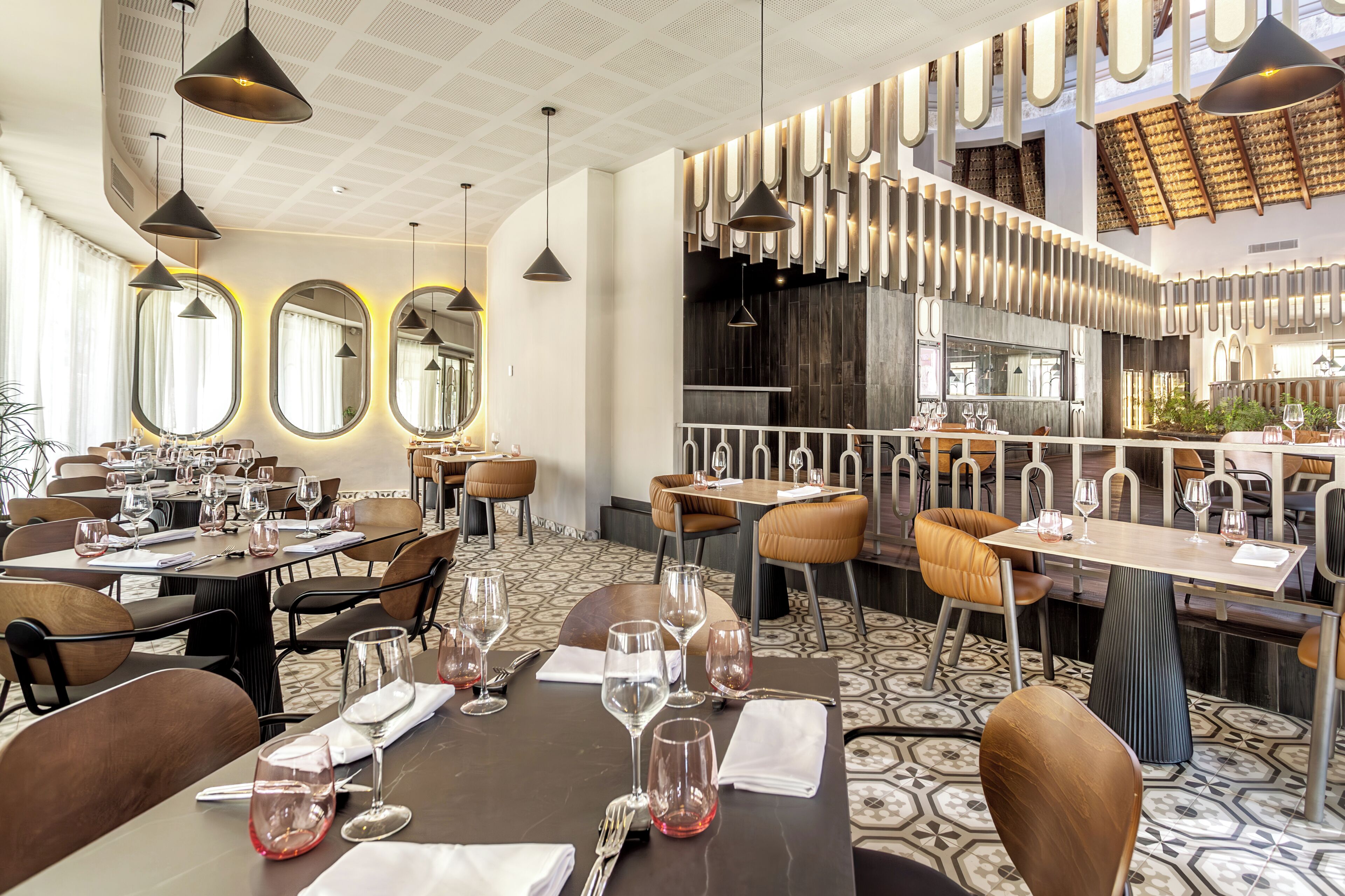 Een restaurant met meerdere eettafels, stoelen en hangende吊灯.