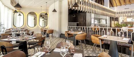 Een restaurant met meerdere eettafels, stoelen en hangende吊灯.