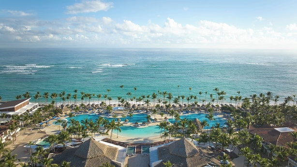 Ein Resort mit großzügigem Poolbereich, Strand und Meerblick.