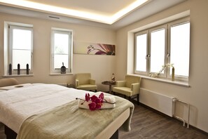 A hotel room with a large bed, two armchairs, a small table, and a window with a view. - Best Western Plus Hotel Böttcherhof (Hamburg)