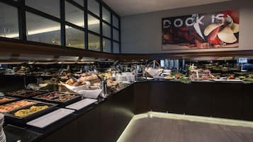 A buffet area with various food options and a large poster on the wall.