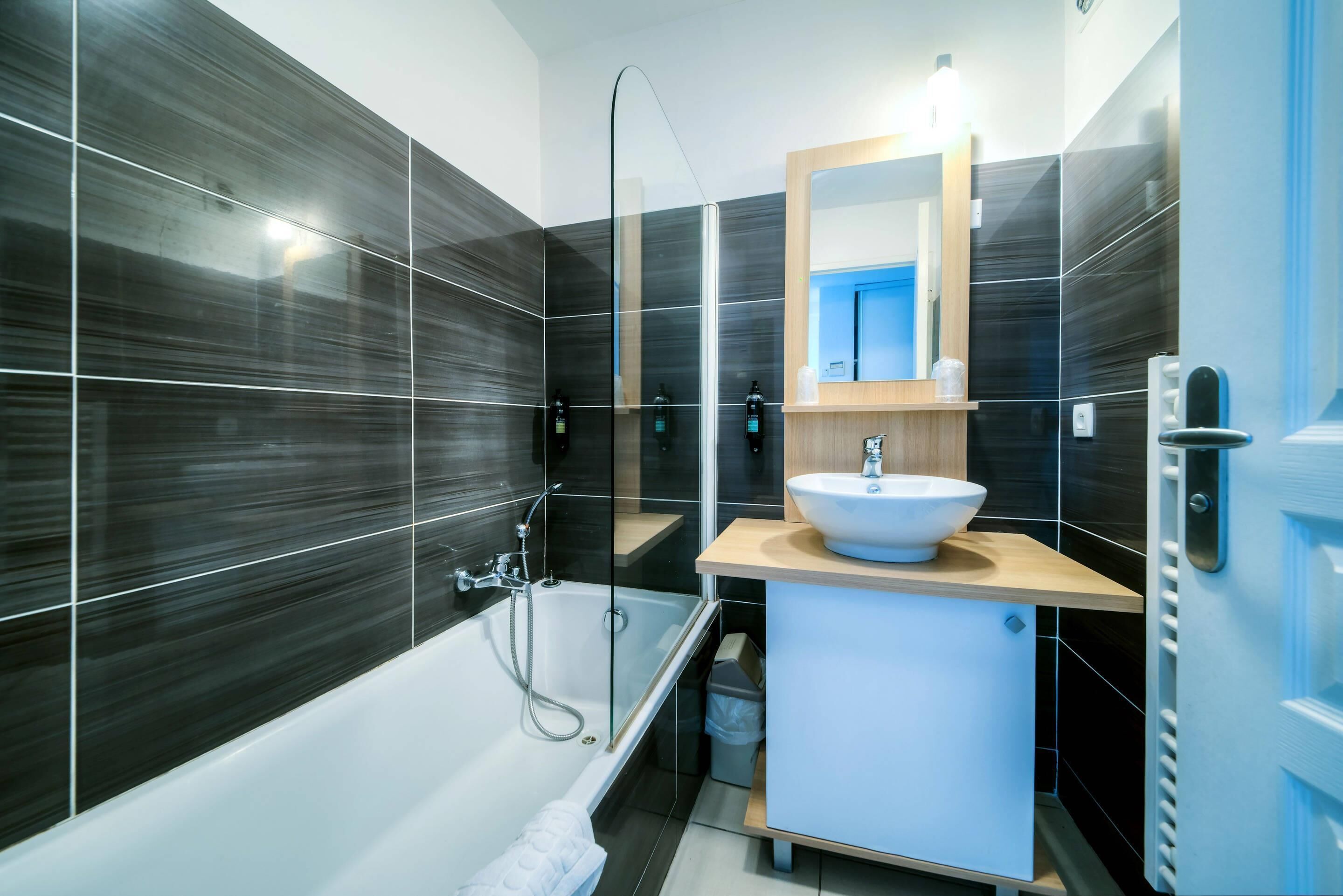 Une salle de bain moderne avec une baignoire, un lavabo et un miroir.