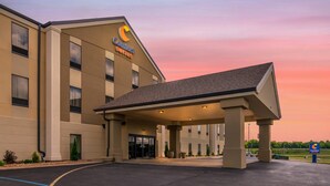 Un hotel Comfort Suites con entrada techada, ventanas amplias y estacionamiento.