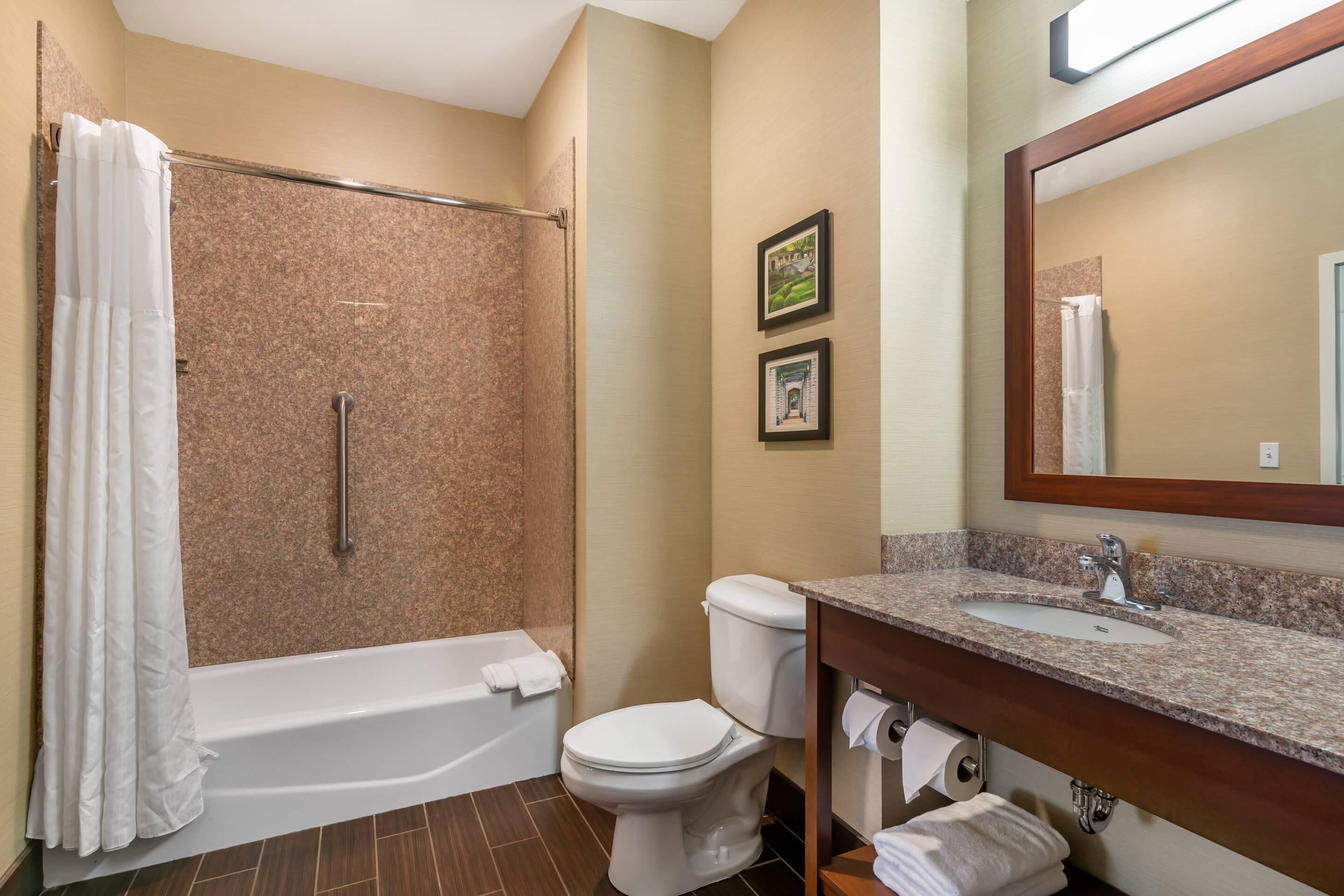 Une salle de bain équipée d’une douche, de toilettes, d’un lavabo et d’un porte-serviettes.