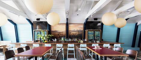 A restaurant with a bar area, checkered floor, and hanging paper lanterns.