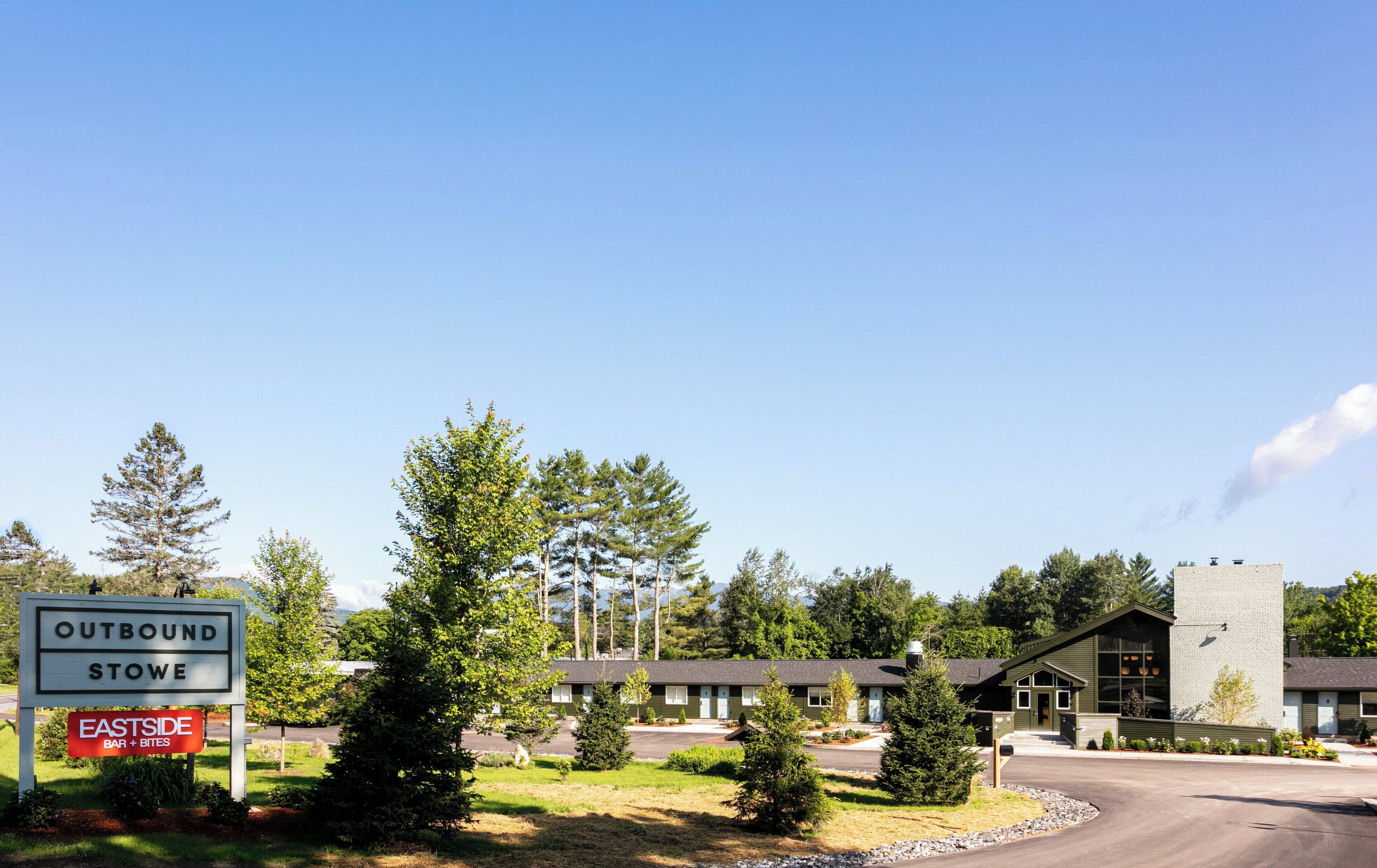 Un motel con un letrero que indica 'OUTBOUND STOWE' y 'EASTSIDE BAR + BITES'.