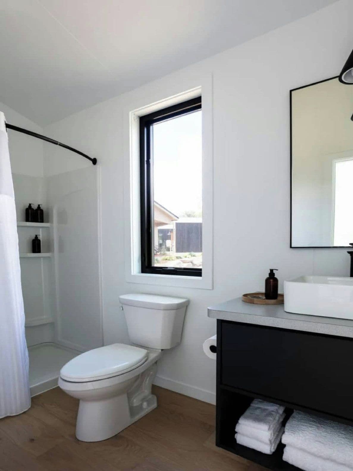 Un baño moderno con inodoro, ducha y lavamanos.