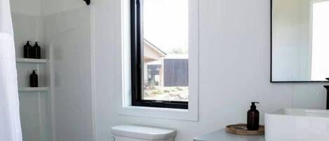 Un baño moderno con inodoro, ducha y lavamanos.