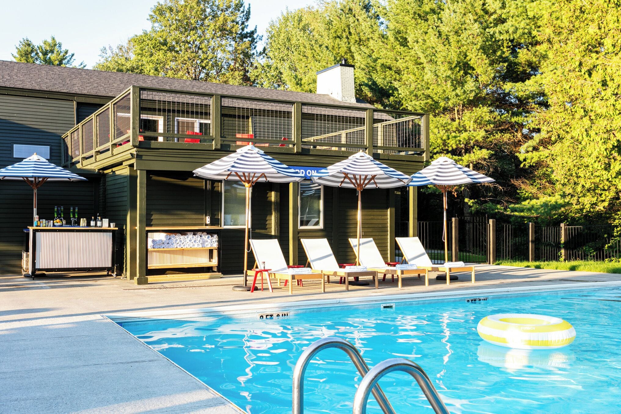 室外游泳池，池畔遮阳伞，日光浴躺椅