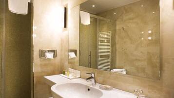 A modern bathroom with a large sink, mirror, and towel rack.