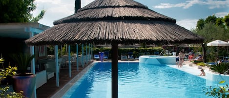 Una piscina cubierta, una piscina al aire libre de temporada, sombrillas