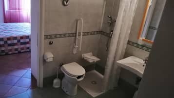 Un baño con inodoro, ducha y lavabo.