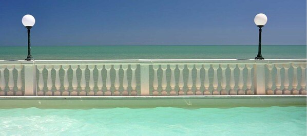 A coastal promenade with a balustrade and two street lamps. - Il Brigantino (Porto Recanati)