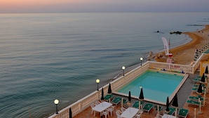 Zona de piscina con vista a la playa y al océano.